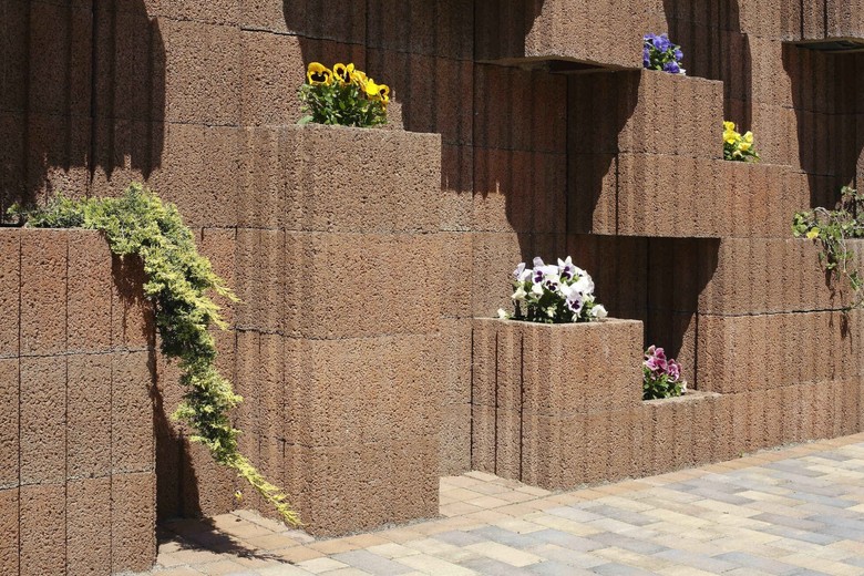 Spojení betonu a květin dodá vašemu plotu originalitu.