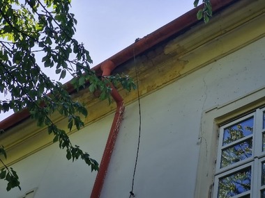Obr. 9: Charakteristické projevy zatékání na fasádu v místě vadného napojení dešťového svodu na střešní žlab