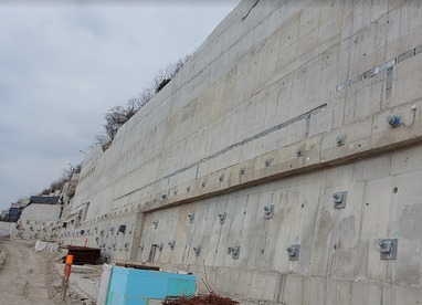 Obr. 5a – Pohľad na západnú časť OM1 (možno vidieť nosníky s 5-lanovými kotvami, nosníky s 19-lanovými kotvami, tyče WR 47 osadené pred líc múru, vylamováky pre kvetináče, odvodńovacie otvory fi 70 mm, v pozadí geodrenážna fólia medzi torkrétom a žb. stenou)